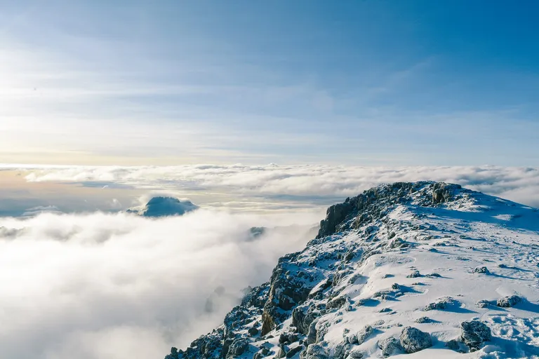Snow-capped summit of Kilimanjaro above a sea of cloud
